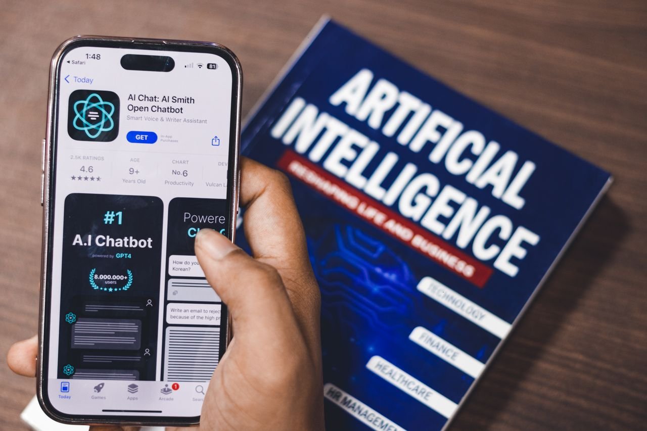 The Art of Drawing Readers In: Your attractive post title goes here Smartphone displaying AI app with book on AI technology in background.